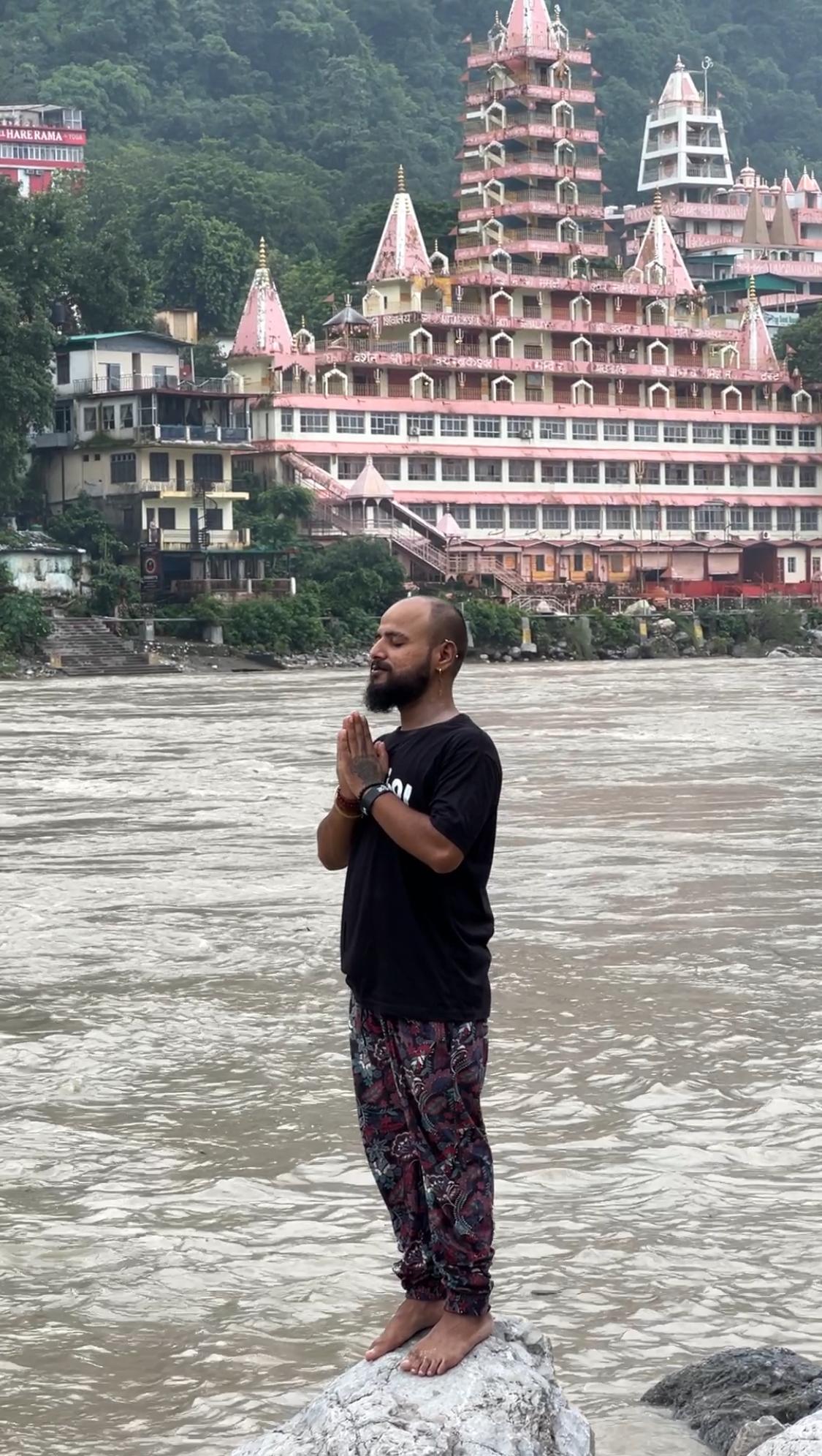 Divyesh in prayer by the river temple